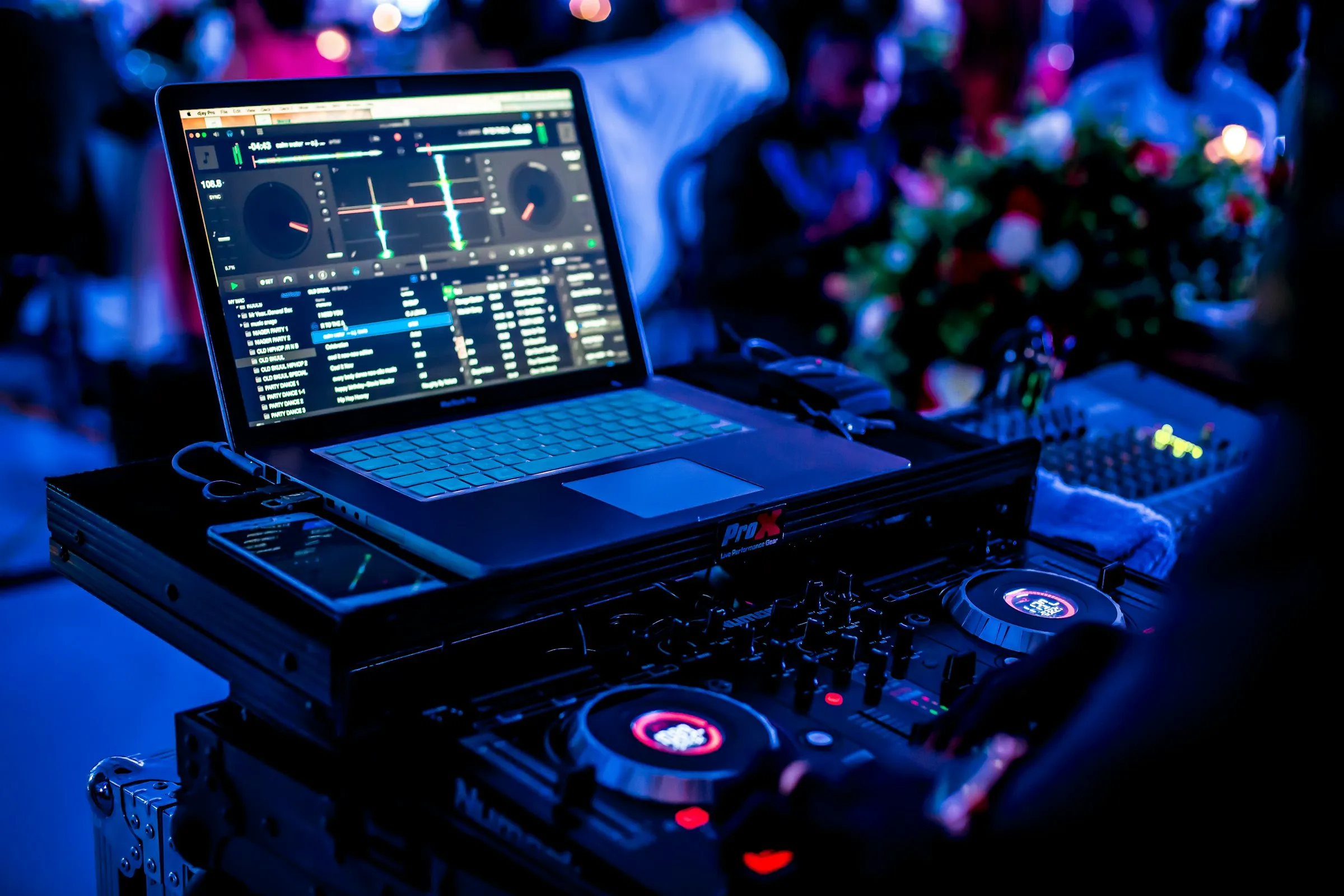 DJ booth with laptop and lit controller